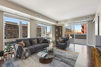 Open and contemporary living space with oversized windows on two walls and ample natural light.